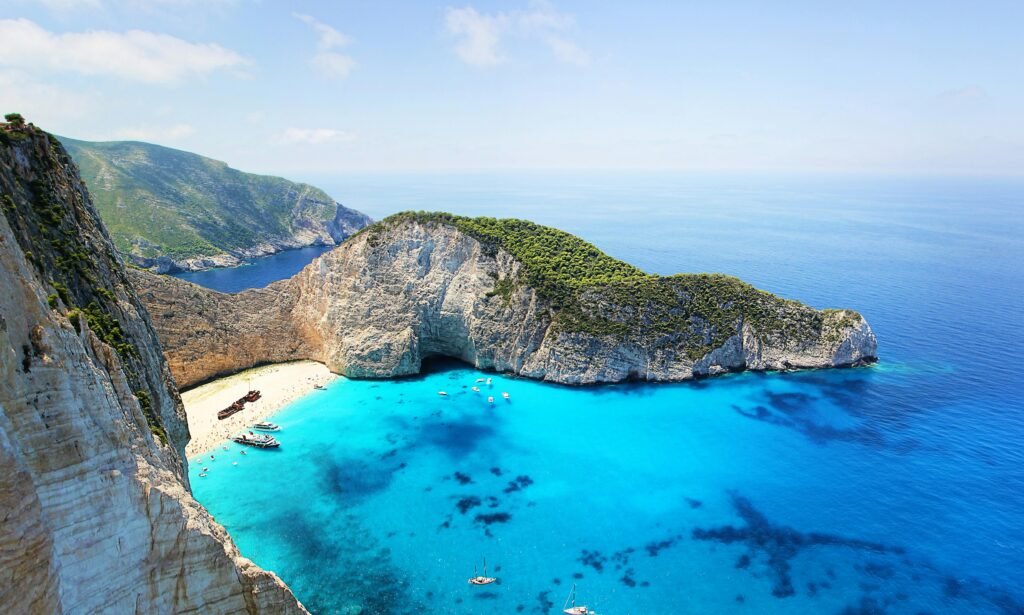 Stunning aerial view of Navagio Beach in Zakynthos, Greece, featuring turquoise water and a sunken ship.